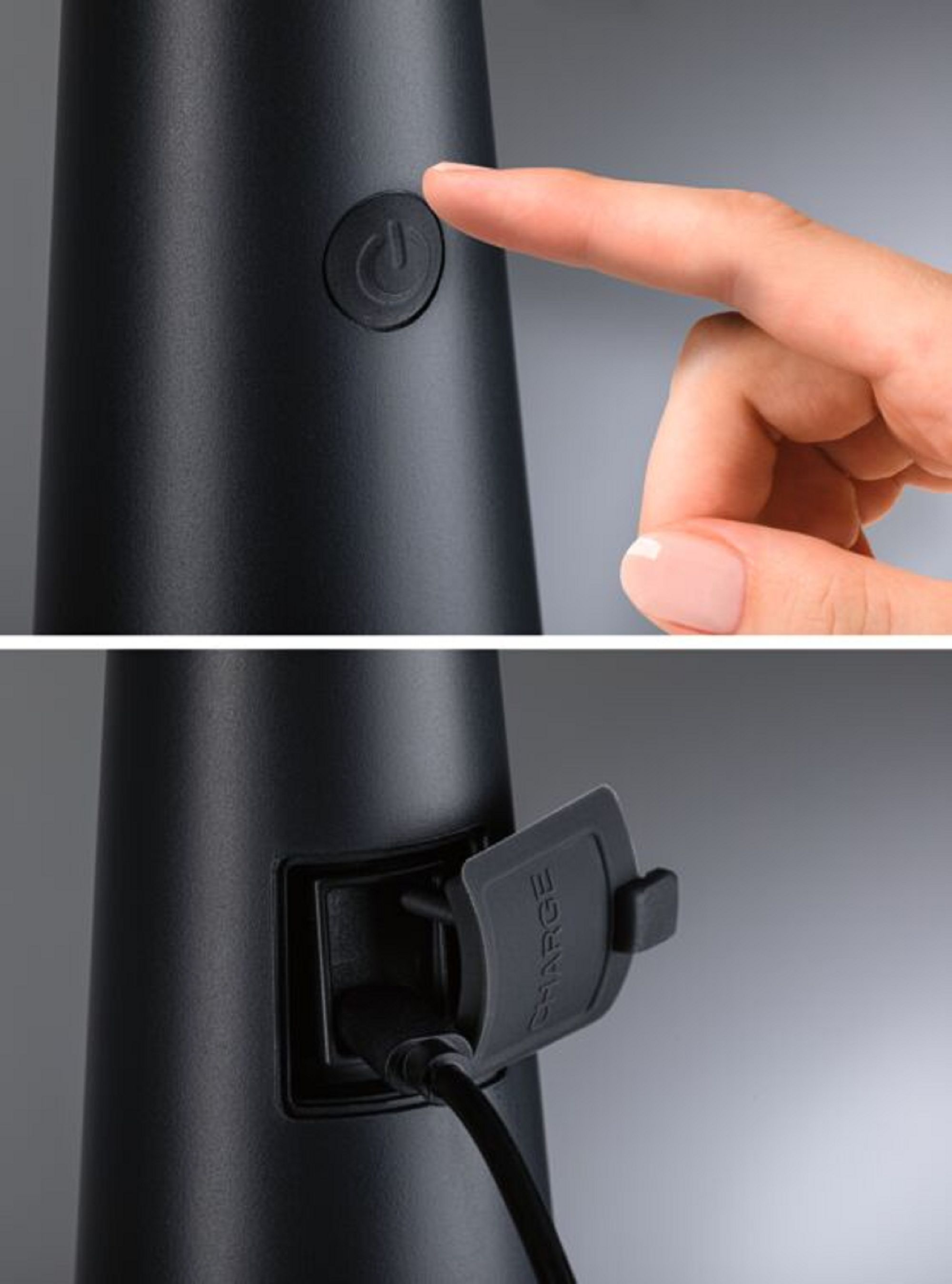 Ręka naciska przycisk zasilania na czarnym, stożkowym urządzeniu, z portem ładowania poniżej.