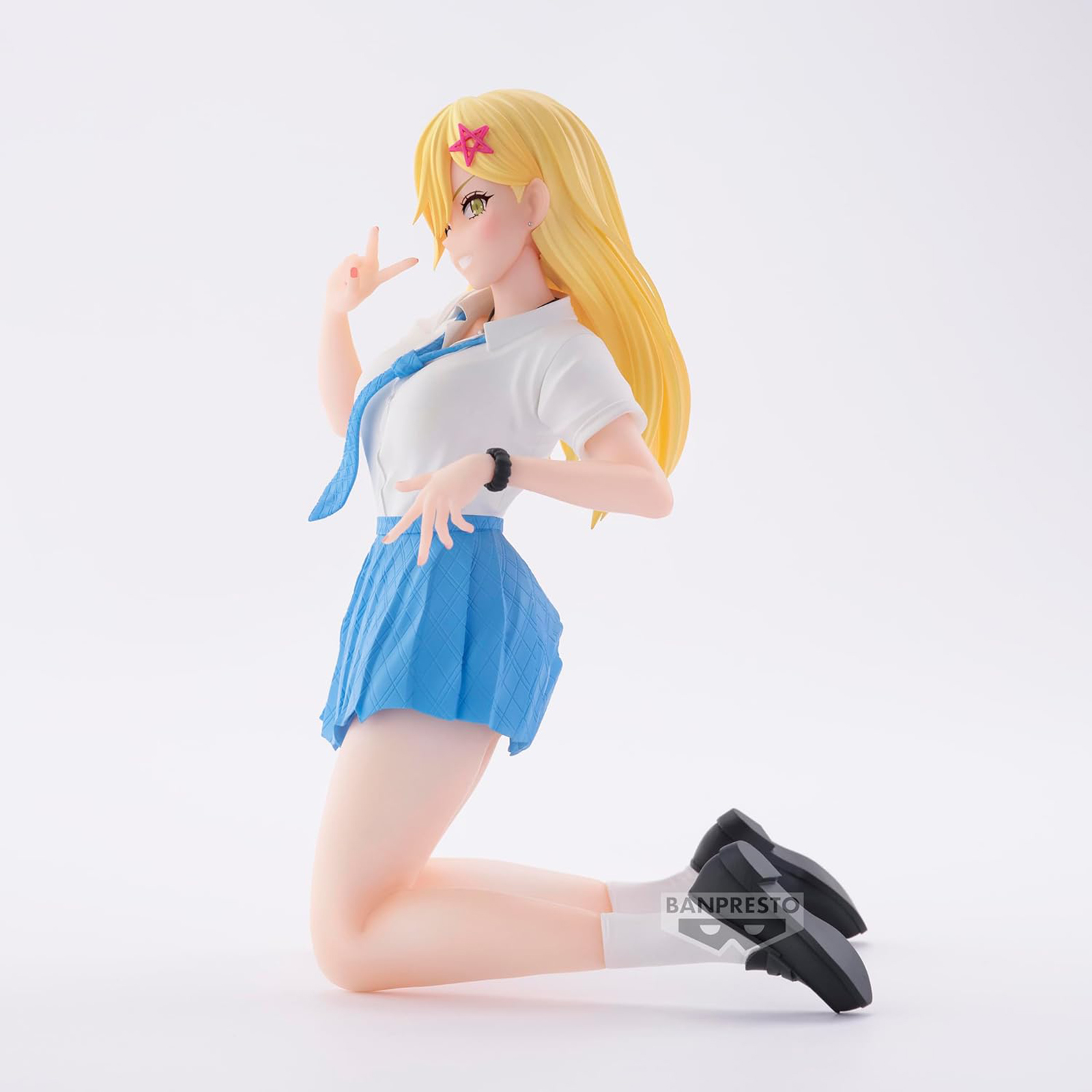 Figura anime de una chica rubia en uniforme escolar, arrodillada con signo de la paz.