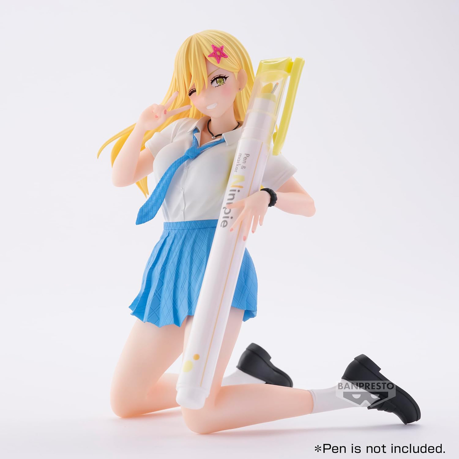 Figura de chica anime arrodillada, sosteniendo un bolígrafo grande. Lleva uniforme escolar.