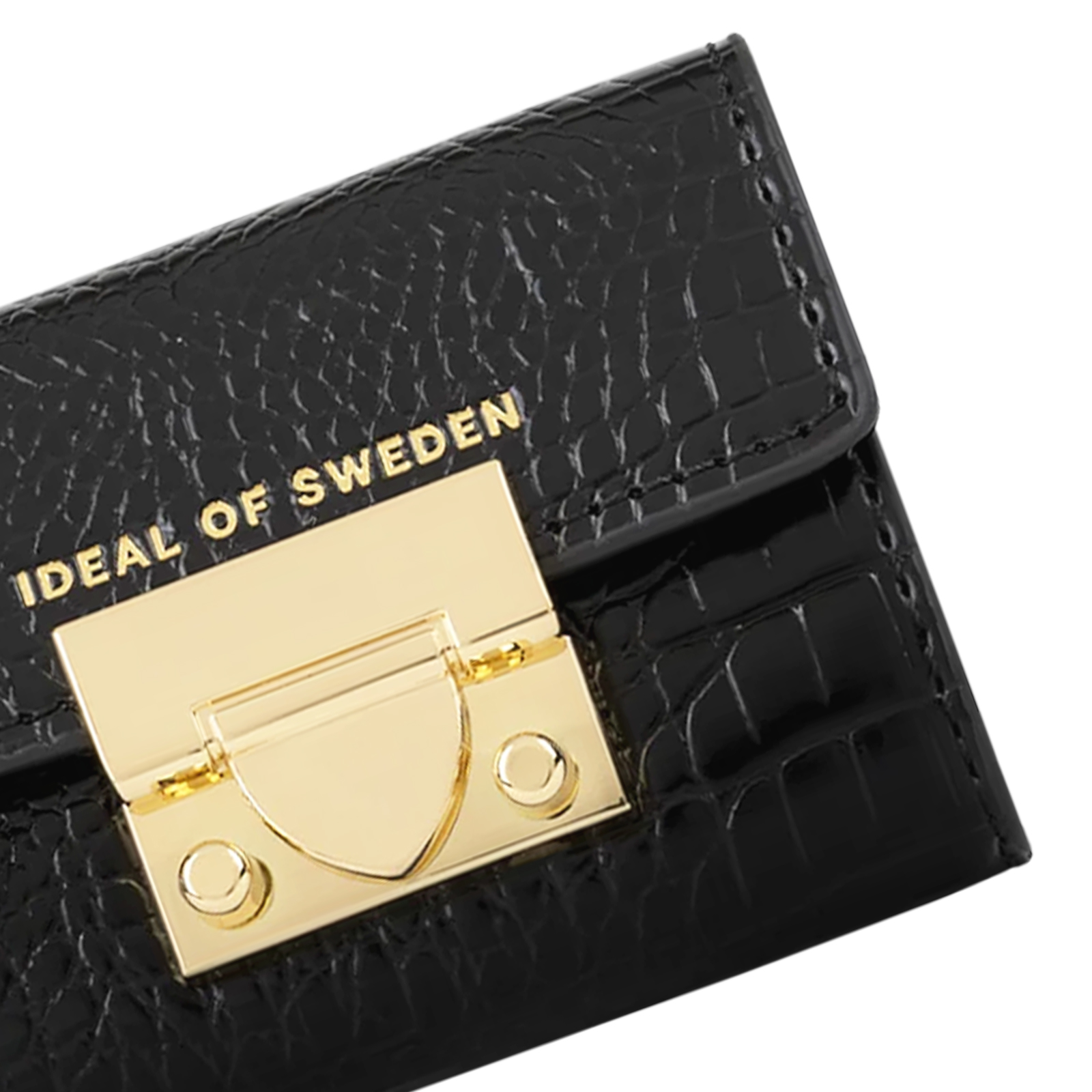 Nahaufnahme einer schwarzen Ledertasche mit goldenem Verschluss und Aufschrift 'IDEAL OF SWEDEN'.
