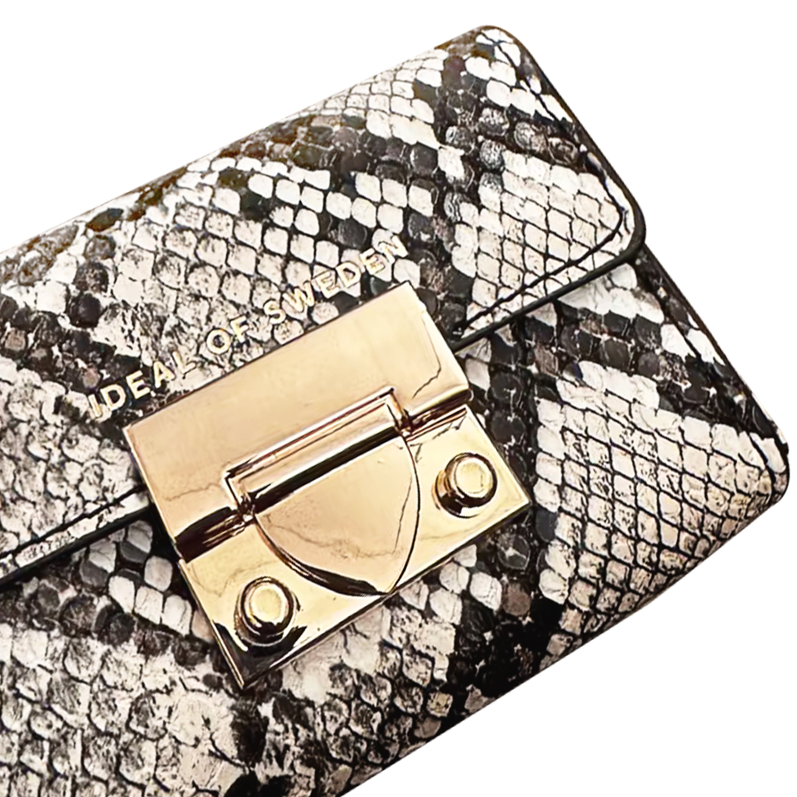 Nahaufnahme einer Clutch mit Schlangenmuster und goldenem Verschluss. Auf der Clutch steht 'IDEAL OF SWEDEN'.