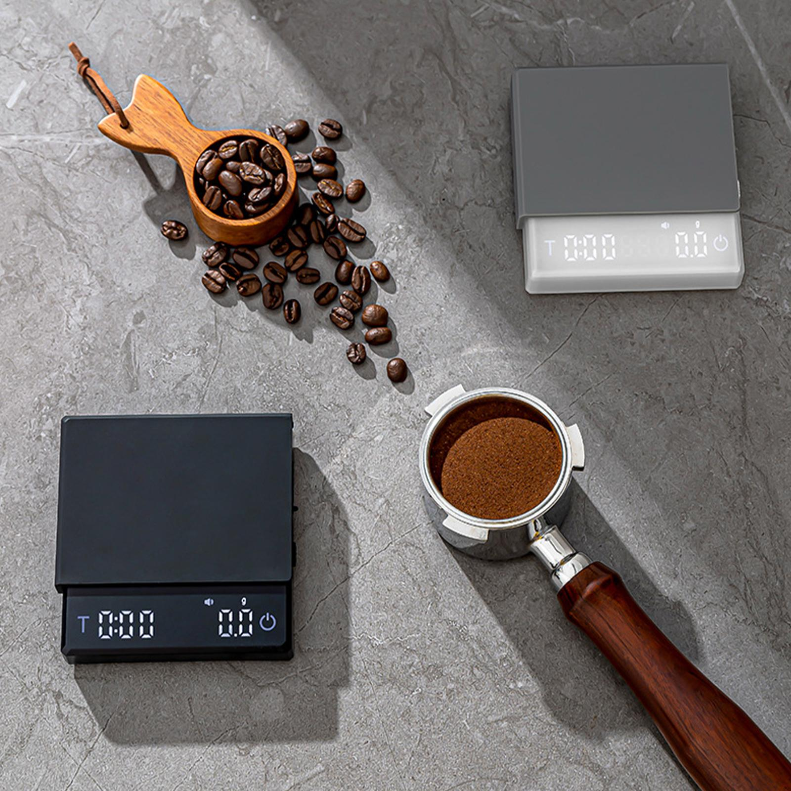 Kaffeebohnen, Löffel und zwei Waagen, plus ein Siebträger mit gemahlenem Kaffee.