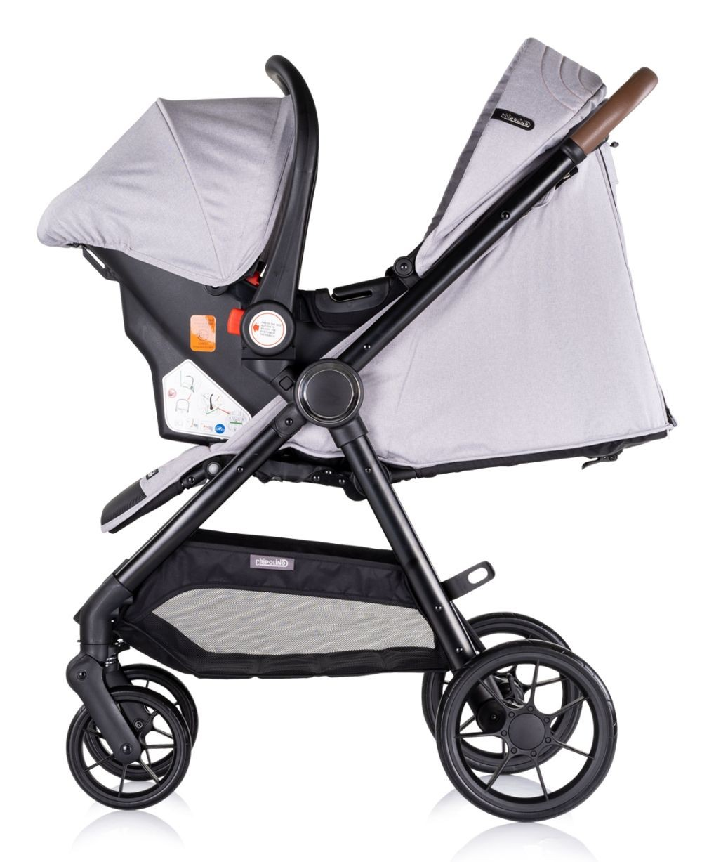 Ein grauer und schwarzer Kinderwagen mit aufgesetztem Autositz. Der Wagen hat einen Korb und große Räder.