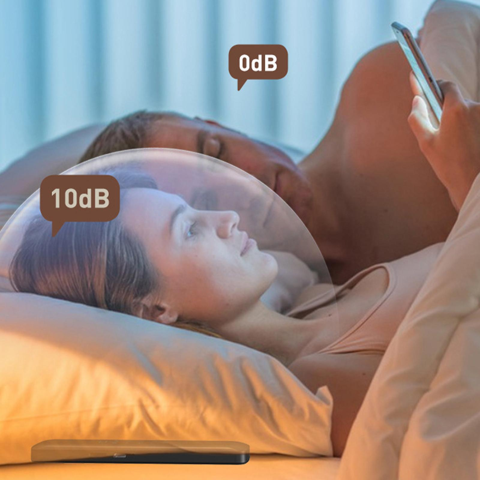 Ein Paar liegt im Bett. Eine Frau schaut auf ihr Handy, während der Mann schläft.
