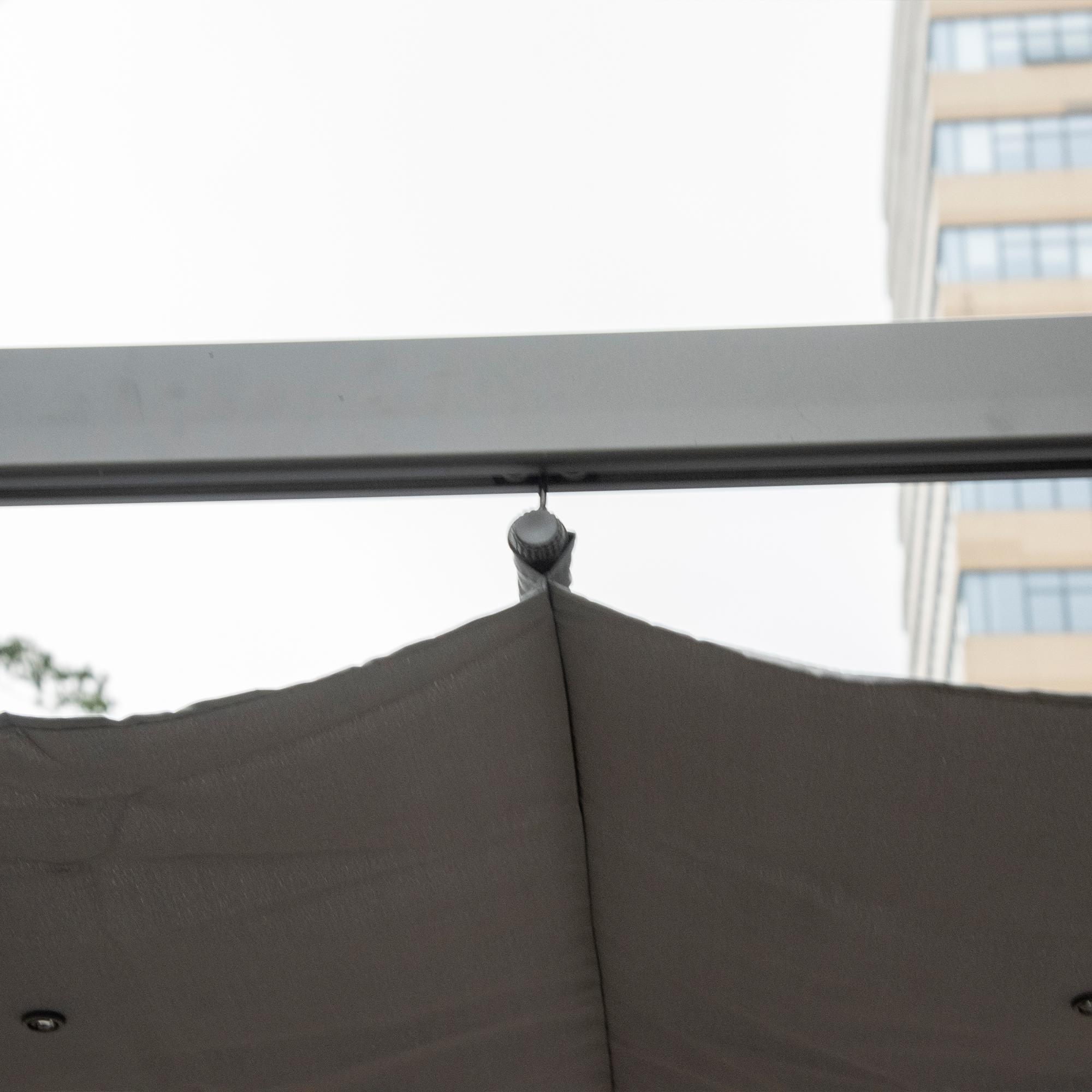 Nahaufnahme eines Pergola-Dachanschlusses. Der Himmel und ein Gebäude sind im Hintergrund.
