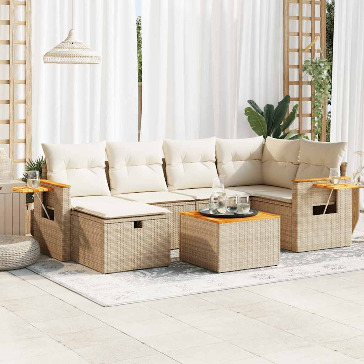Un'ambientazione da patio con un divano in vimini, un tavolo e accessori, con tende bianche sullo sfondo.