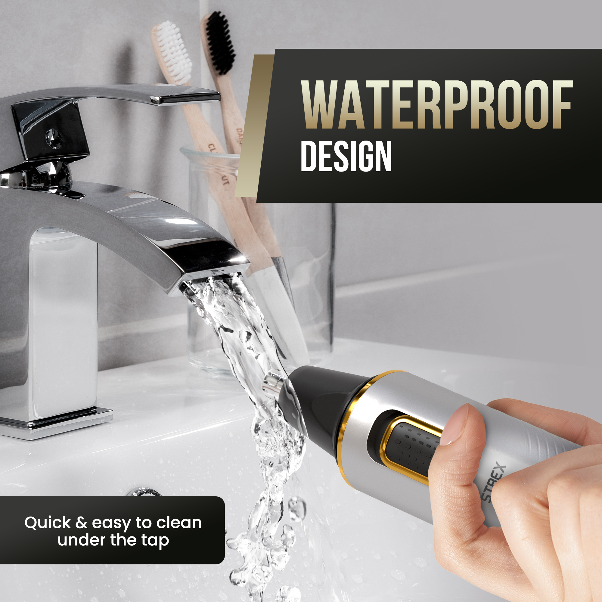 A nose hair trimmer under running water. The trimmer is silver and black with a golden trim. Two toothbrushes in the background.