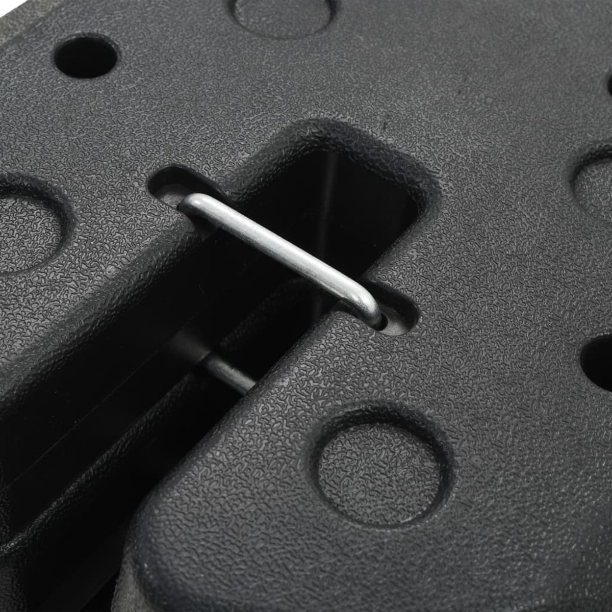 Primo piano di una base di plastica nera con diversi fori e una barra di metallo.