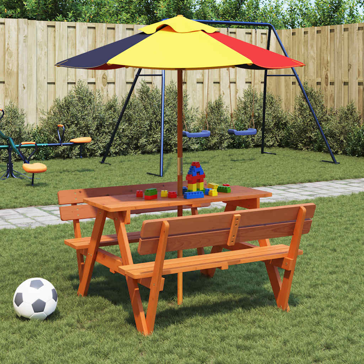 Picknicktisch mit Sonnenschirm im Garten. Ein Fußball liegt auf dem Rasen. Legosteine auf dem Tisch.