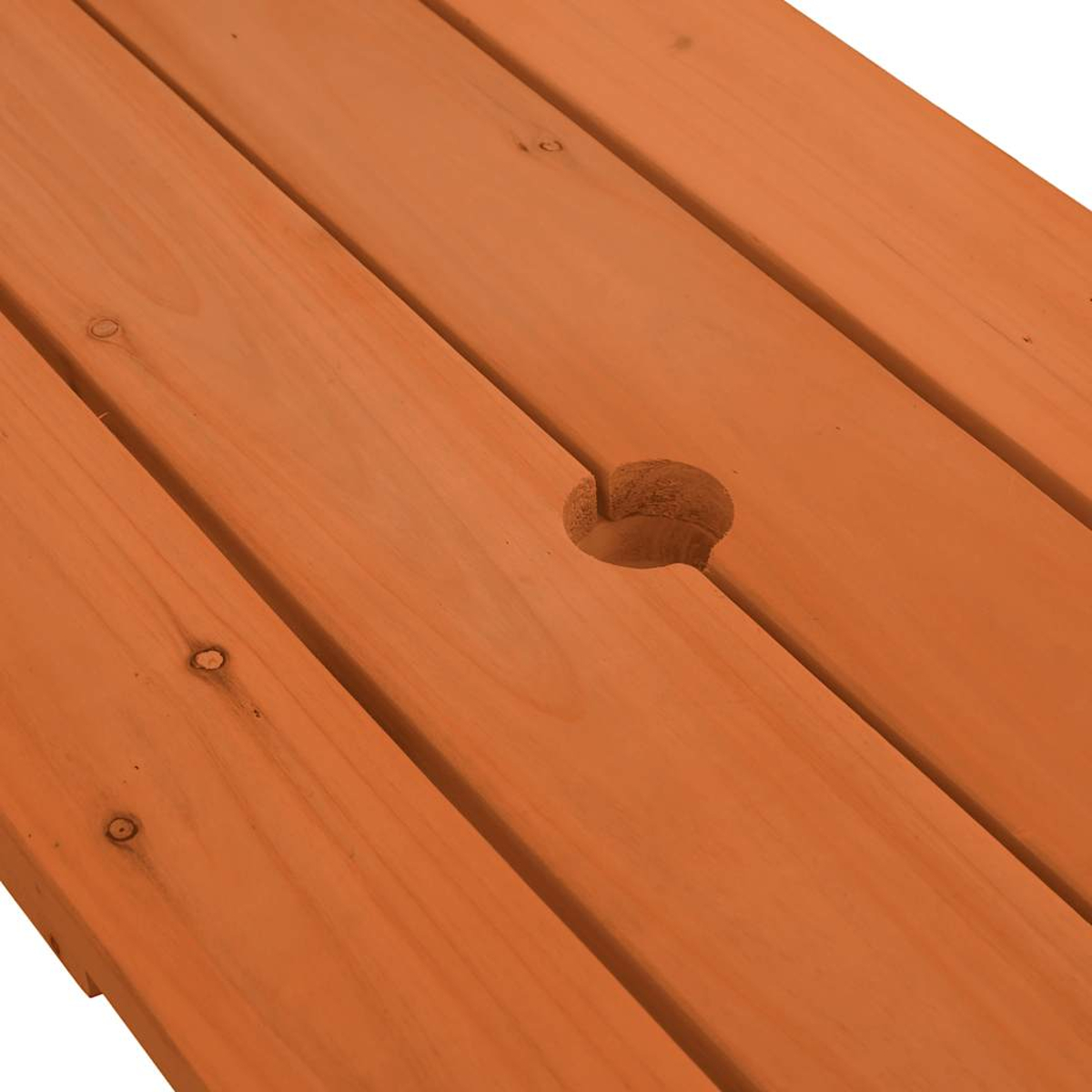 Nahaufnahme eines Picknicktisches mit Loch. Das Holz ist orange-braun mit Maserung.