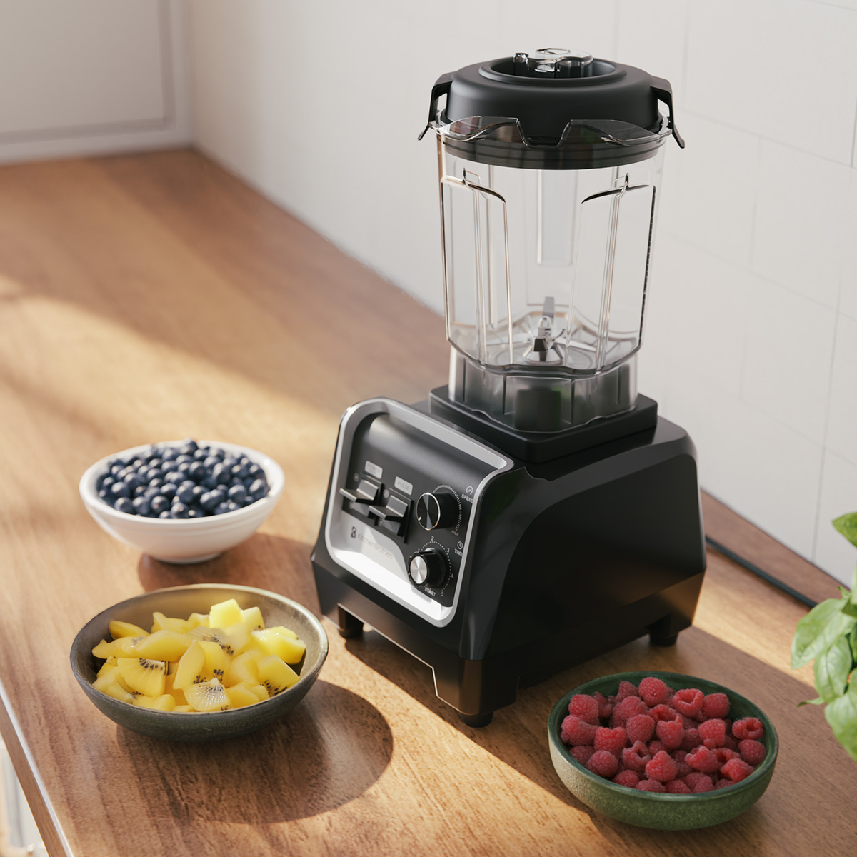 Black blender with fruit bowls: blueberries, kiwi, raspberries on a wooden surface.