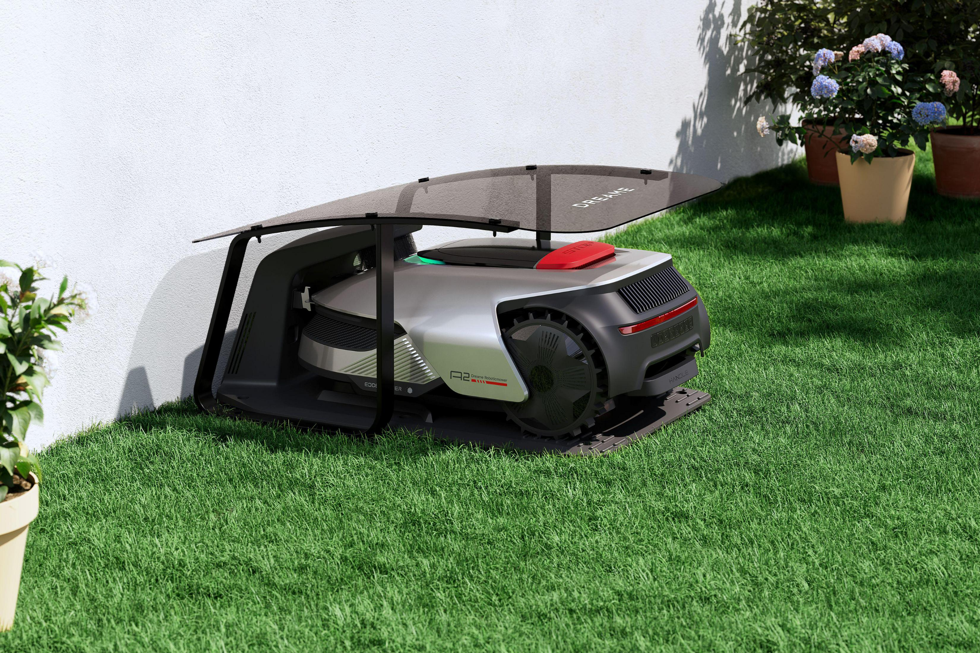 Ein Roboter-Rasenmäher in einer Ladestation auf einem grünen Rasen.
