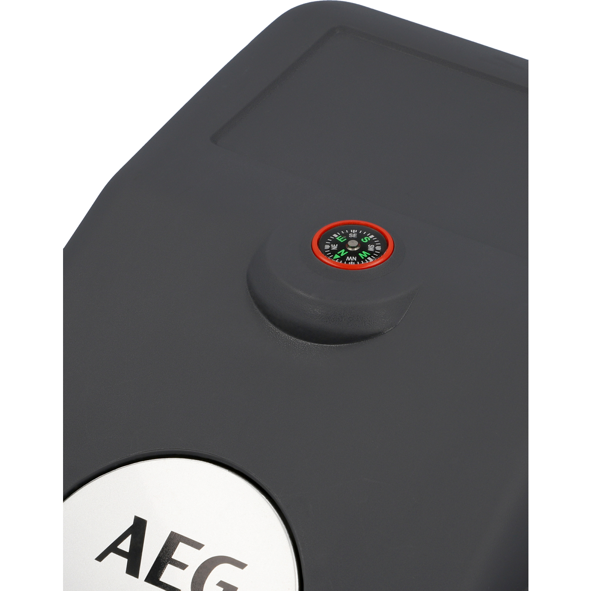 Primo piano di un coperchio nero, grigio e argento con un quadrante a forma di bussola e un logo AEG.