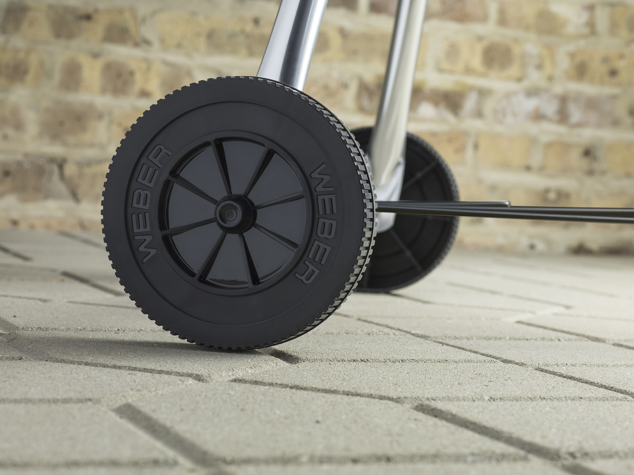 Zbliżenie czarnego koła grilla Weber. Na kole widnieje napis 'WEBER'.