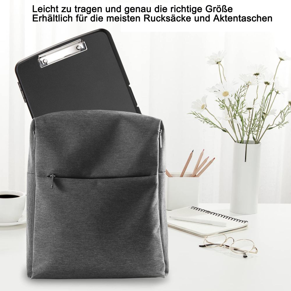 Ein Rucksack mit einer schwarzen Klemmbrett im Inneren, neben Blumen, einem Stift, einer Brille und einer Tasse Kaffee.