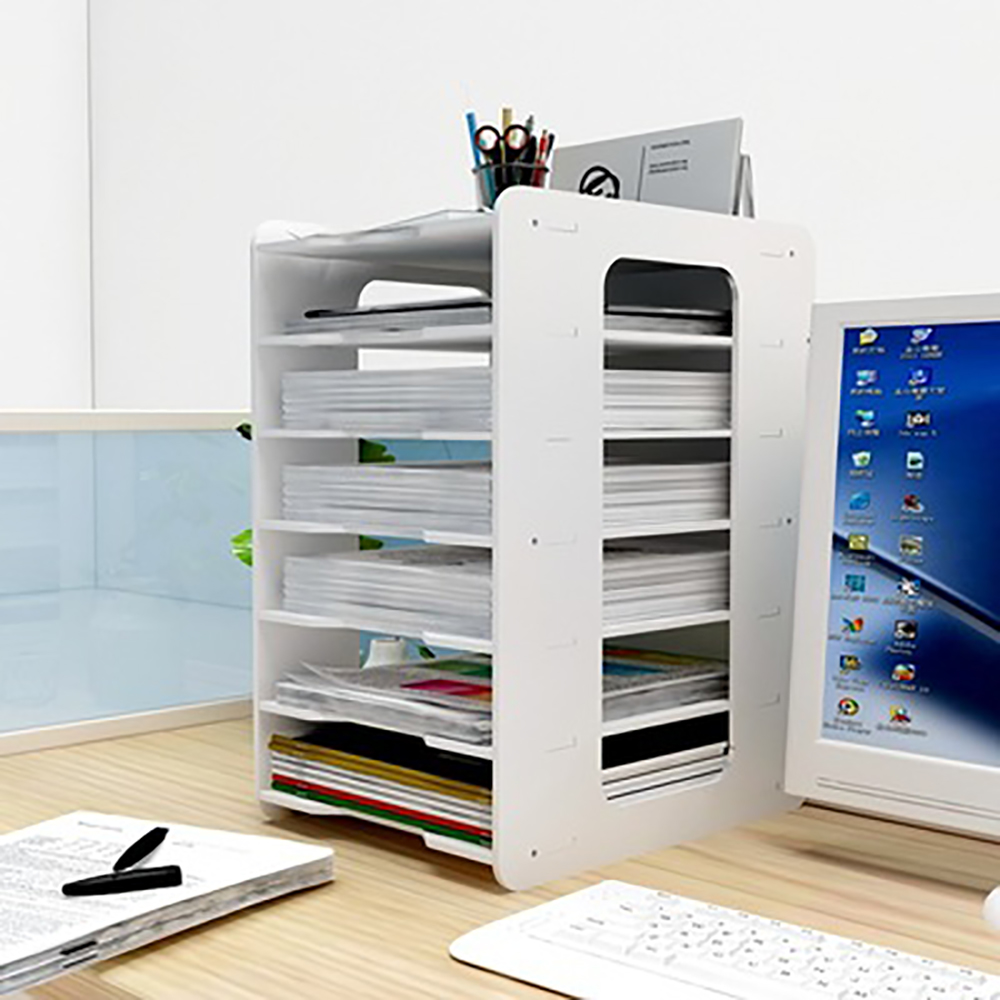 Ein weißer Büro-Organizer mit Papieren und einem Computermonitor im Hintergrund.