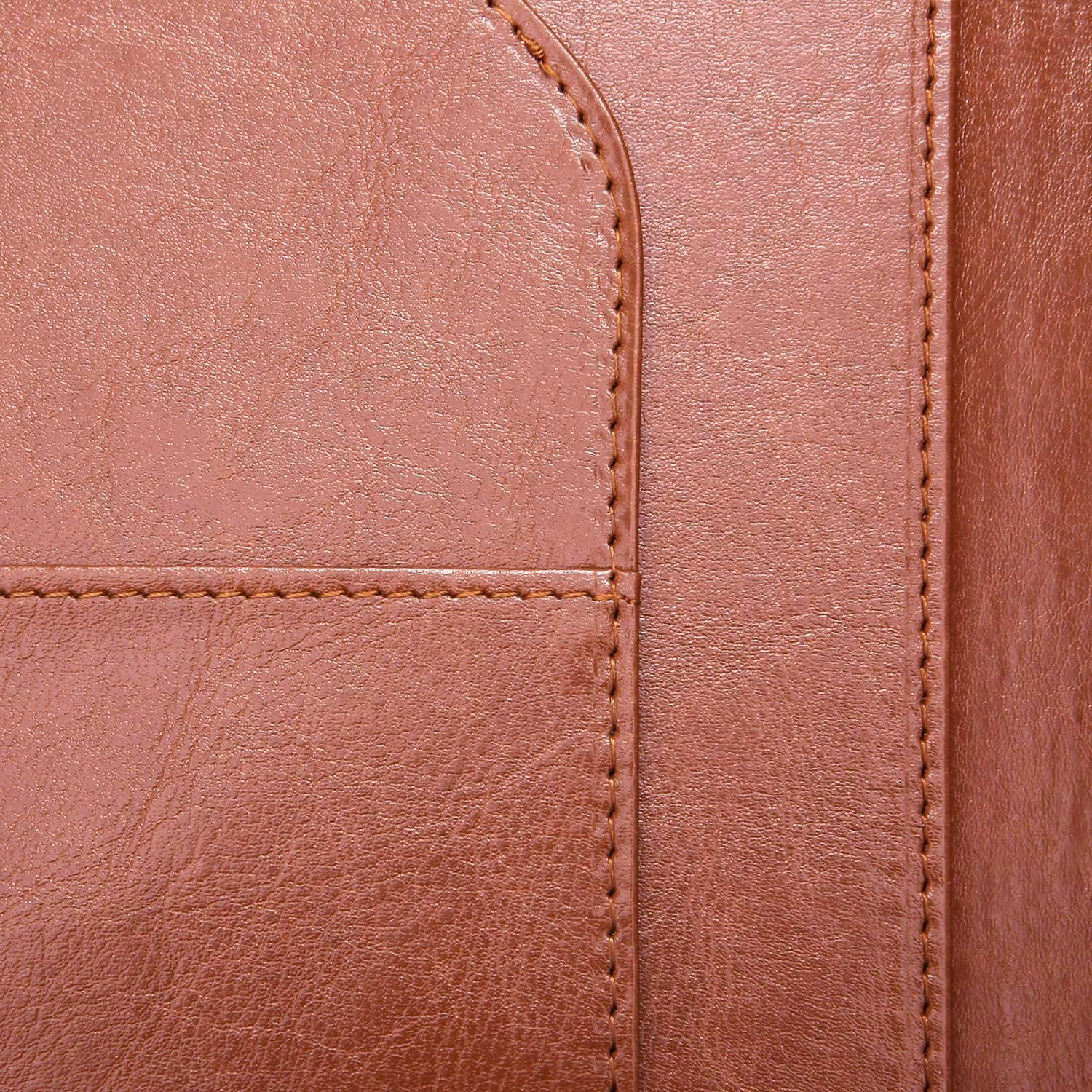 Nahaufnahme von braunen Lederoberflächen mit Nähten, die eine Tasche auf der linken Seite zeigen.