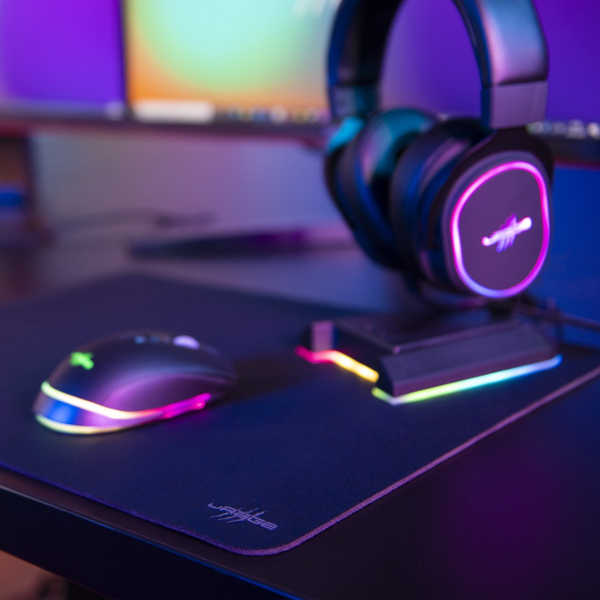 Gaming-Setup mit Headset, Maus und Mauspad. Alle mit farbenfroher RGB-Beleuchtung.