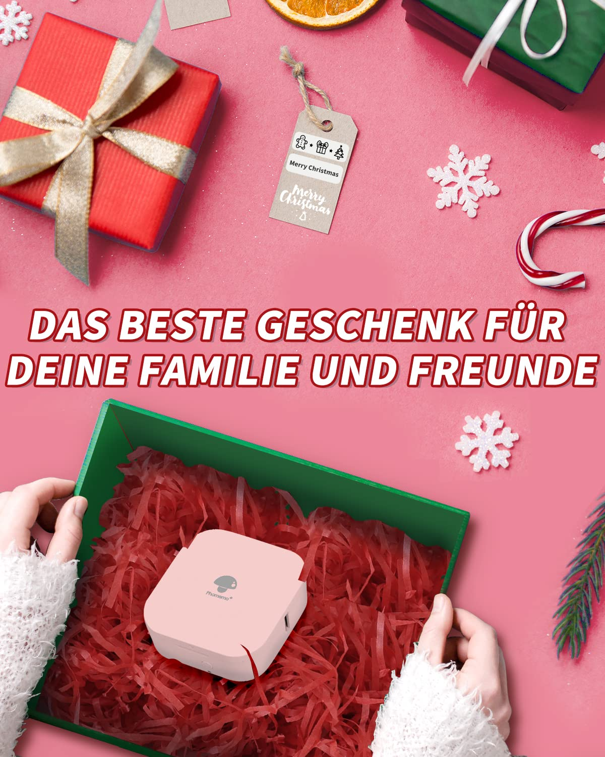 Eine Geschenkbox mit einem rosa Artikel darin. Es ist auf einem rosa Hintergrund mit Weihnachtsdekorationen.