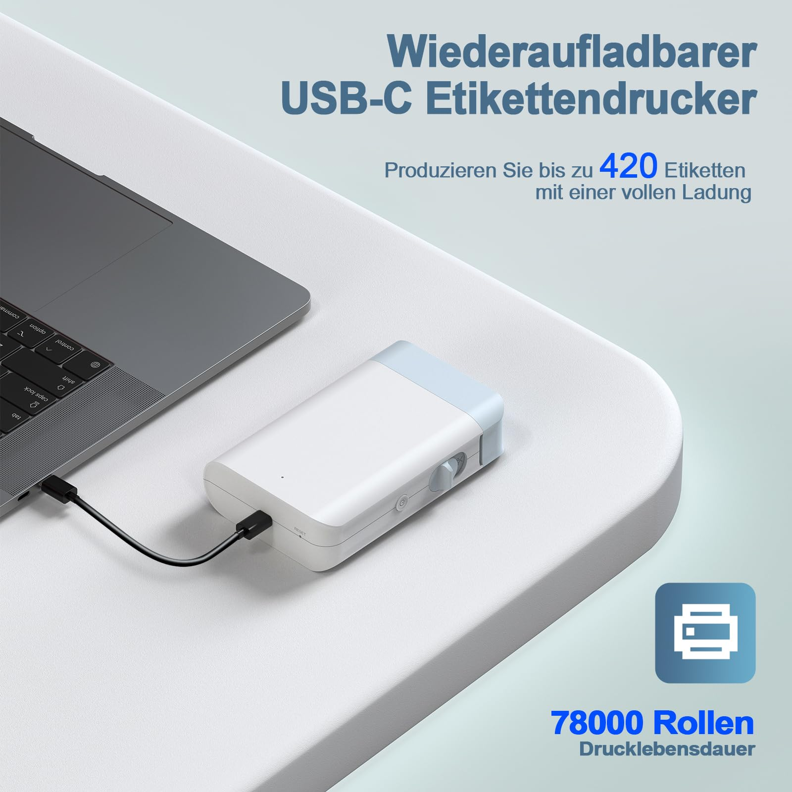 Ein weißer Etikettendrucker liegt auf einer weißen Oberfläche mit einem Laptop. Text besagt, dass er über USB-C aufladbar ist. 420 Etiketten pro Ladung.