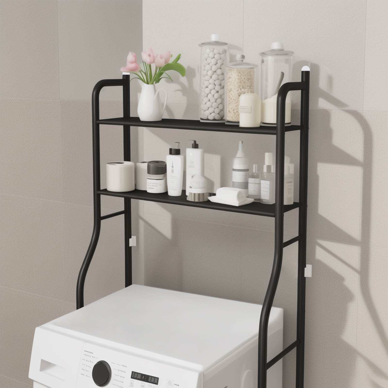 Schwarzes Metallregal über einer weißen Waschmaschine. Regale halten Gläser, Flaschen und eine Vase mit rosa Blumen.