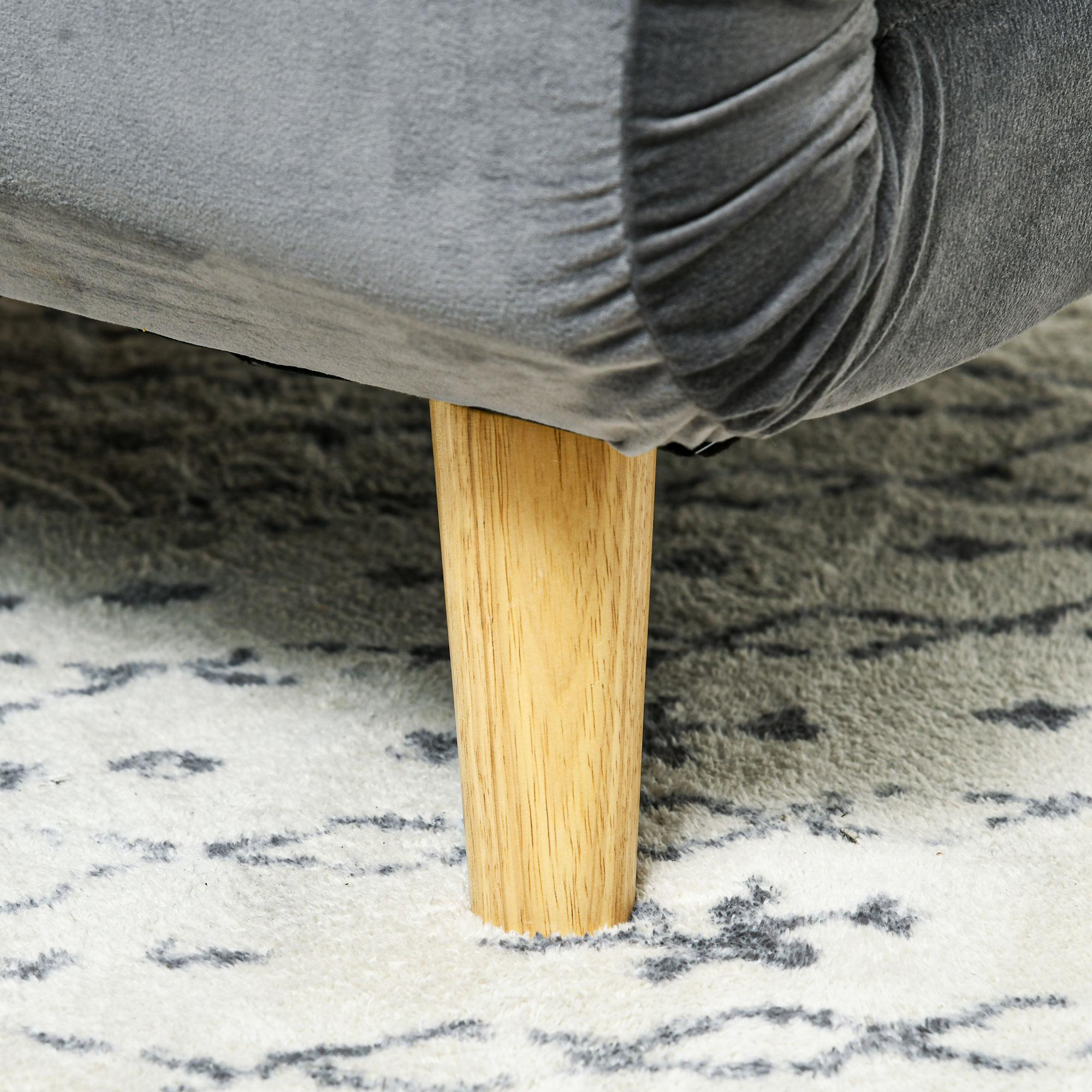 Ein Holzbein eines grauen Sofas. Das Sofa steht auf einem gemusterten weißen Teppich.