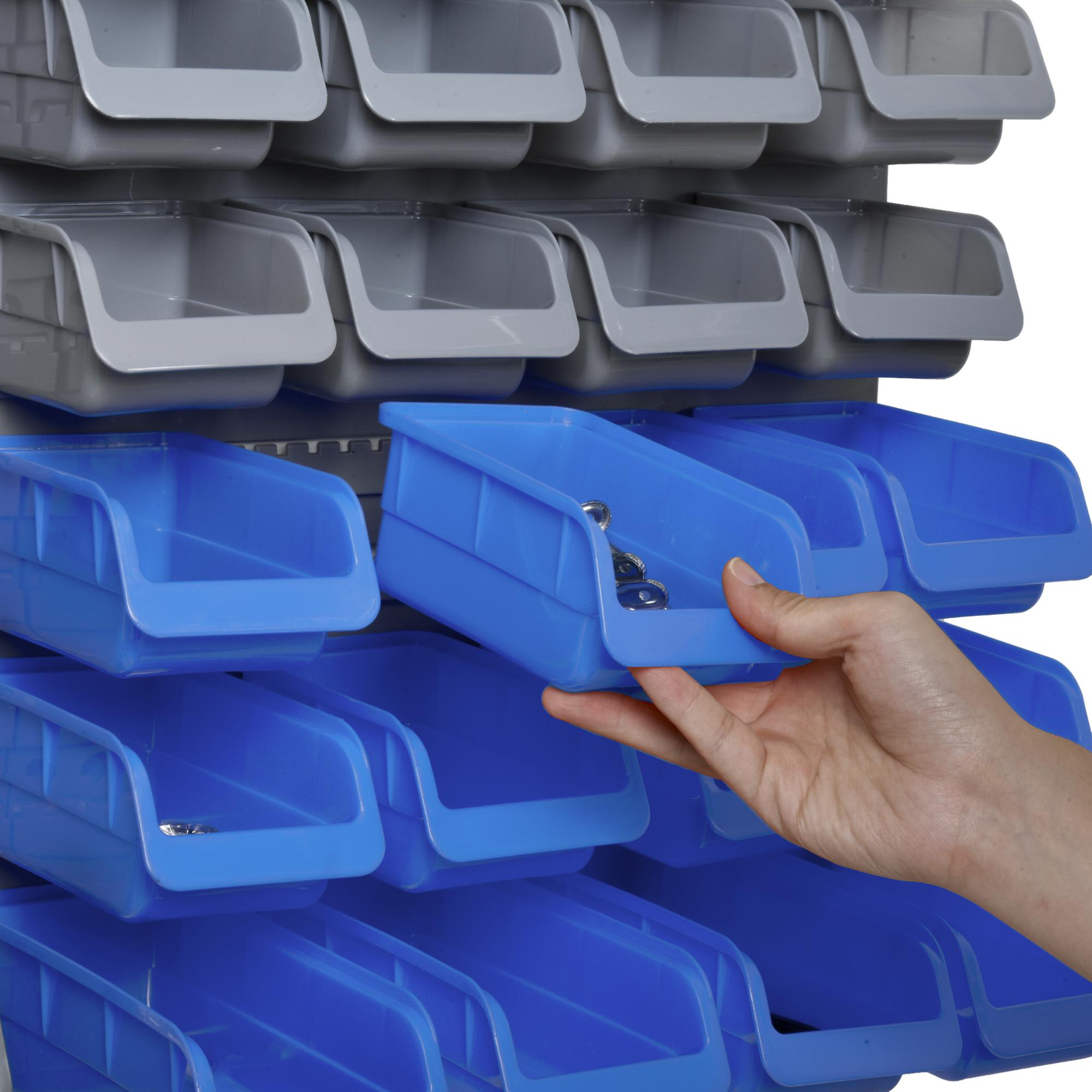 Eine Hand greift in eine blaue Kiste mit kleinen Metallgegenständen. Viele andere blaue Kisten sind im Hintergrund.