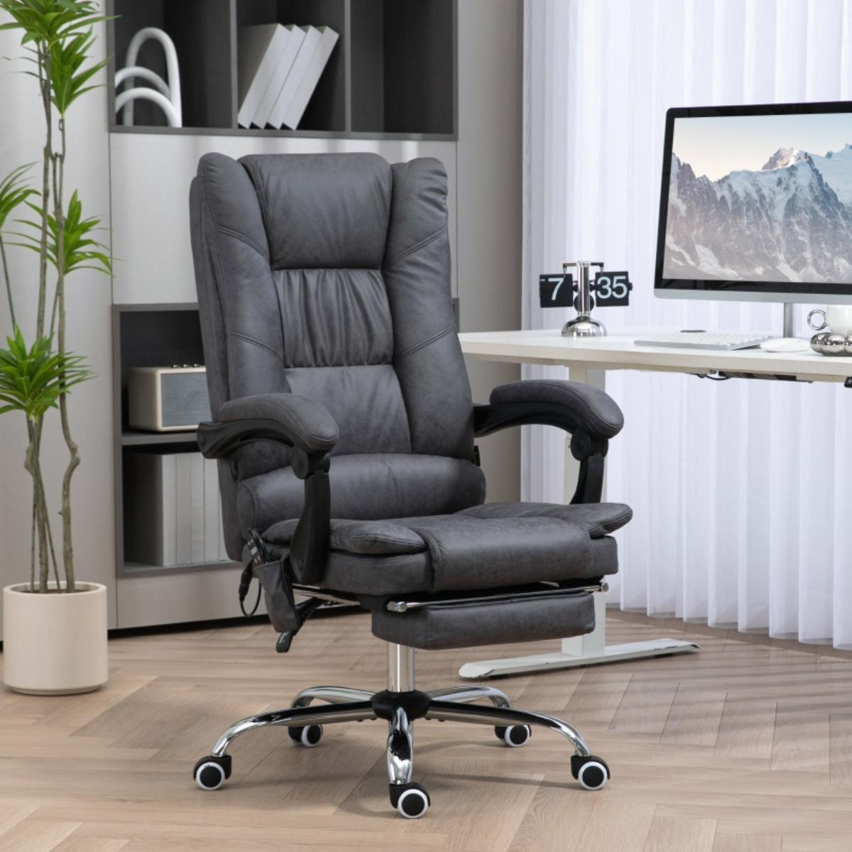 Grauer Leder-Bürostuhl mit Fußstütze und Schreibtisch. Büroumgebung mit Computer, Pflanze und Fenster.