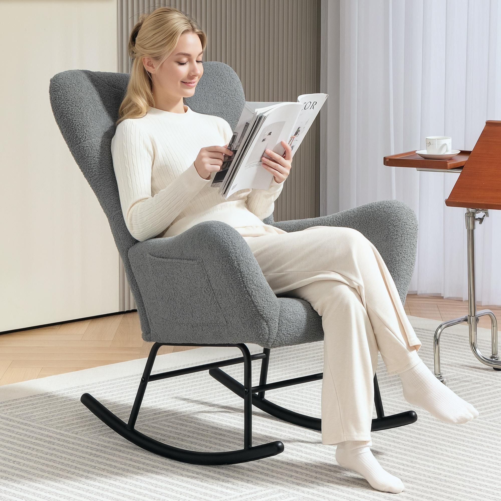 Frau in einem grauen Schaukelstuhl, liest ein Buch. Ein Tisch und eine Kaffeetasse stehen neben ihr.