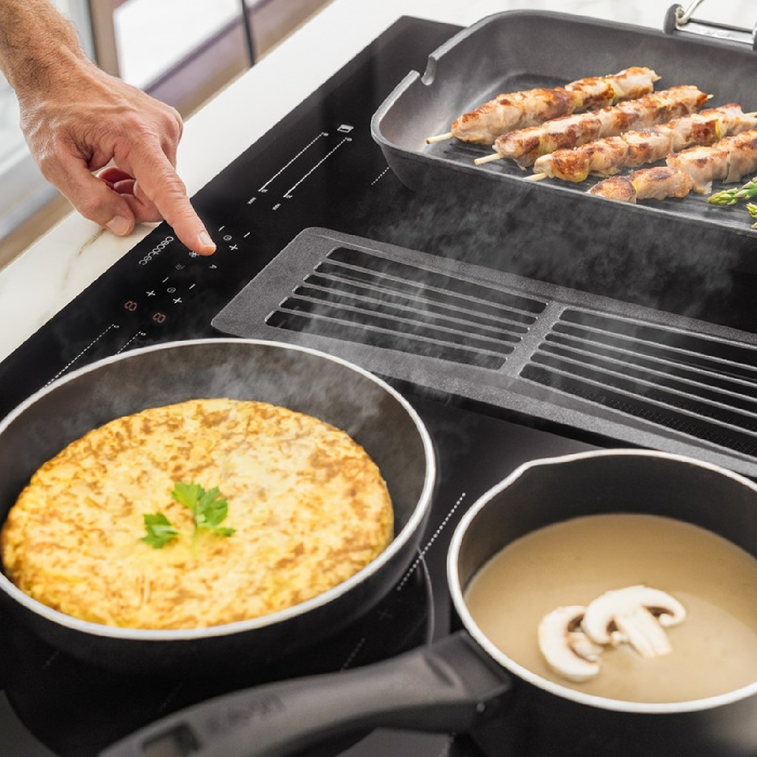 Płyta indukcyjna z gotującym się jedzeniem: jajka, zupa i kebaby. Ręka dotyka płyty.