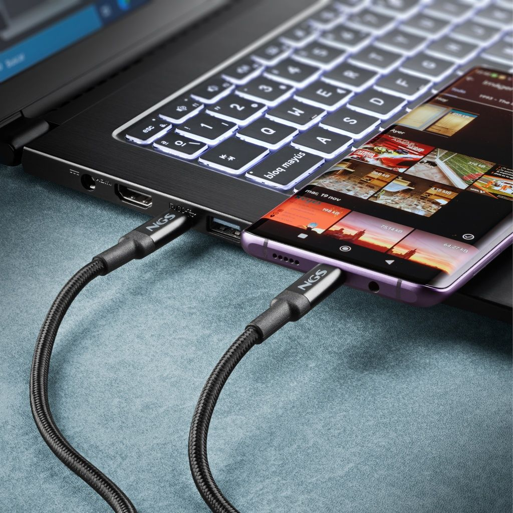 Un teléfono está conectado a una computadora portátil con un cable de carga negro. El teléfono muestra una pantalla.