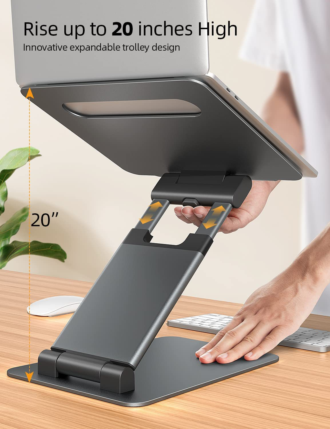 Laptop auf einem schwarzen Ständer. Eine Hand legt etwas auf den Ständer. Holzschreibtisch.
