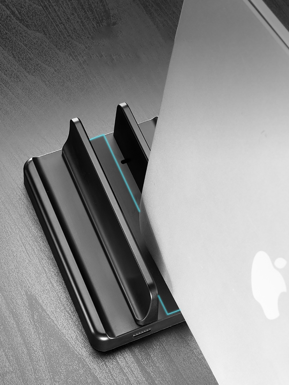 Schwarzer Laptopständer, der einen Laptop hält. Zeigt den Ständer und einen Laptop mit dem Apple-Logo im Hintergrund.