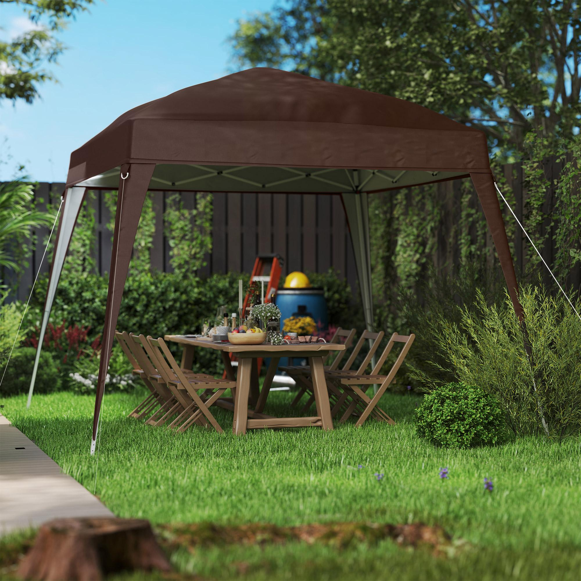 Ein braunes Zelt mit einem gedeckten Tisch, umgeben von Stühlen in einem Garten.
