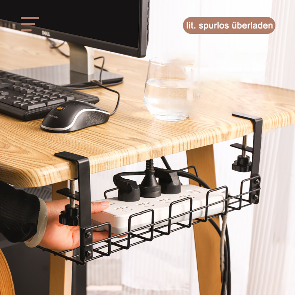 Schwarzer Kabelorganisator unter einem Holzschreibtisch. Hält eine Steckdosenleiste und Kabel. Eine Hand greift hinein.