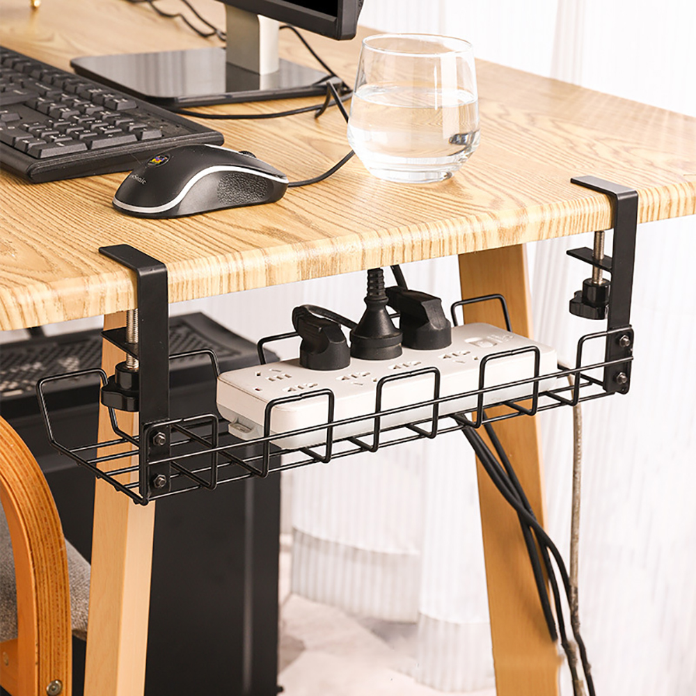 Ein schwarzer Kabelorganizer, der unter einem Holztisch montiert ist und eine Steckdosenleiste und ihre Kabel hält.