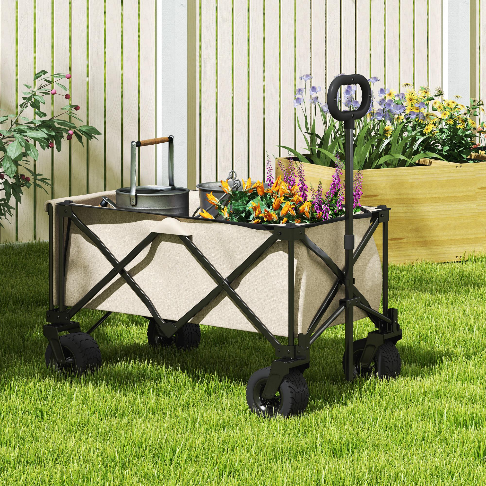 Zusammenklappbarer Wagen mit Blumen und Werkzeugen. Er steht auf Gras, mit einem weißen Zaun im Hintergrund.