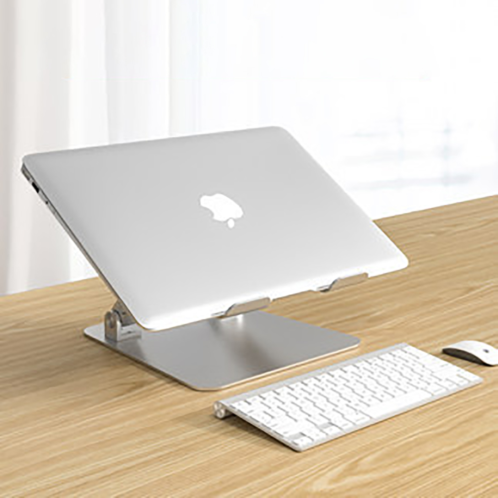 Laptop auf einem silbernen Ständer mit Tastatur und Maus auf einem Holzschreibtisch.