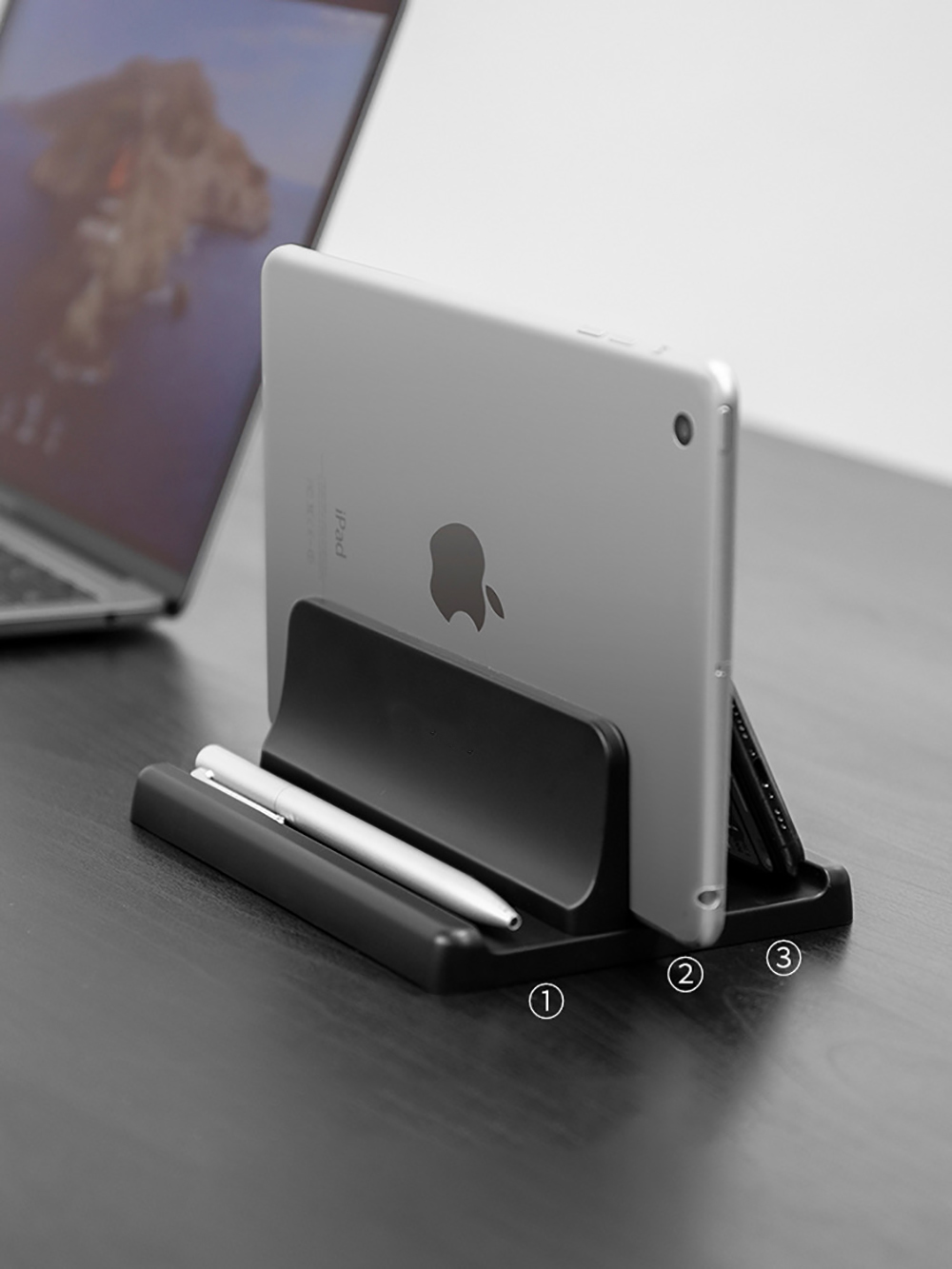 Schwarzer Ständer mit einem Tablet und Stiften. Der Ständer hat 3 Schlitze für Stifte.