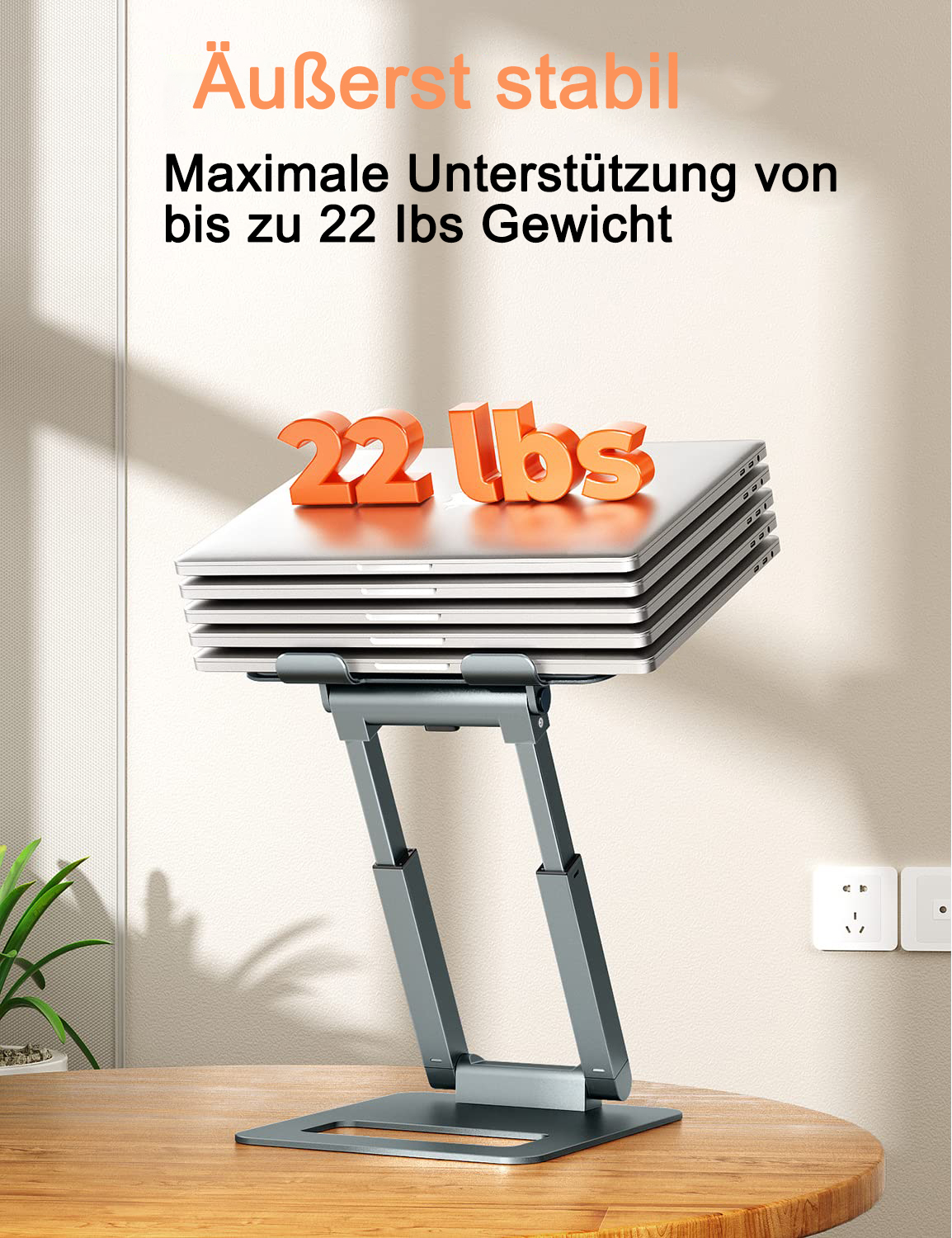 Laptop auf grauem Ständer. Mehrere Laptops oben gestapelt. Text auf Deutsch über die Tragfähigkeit.