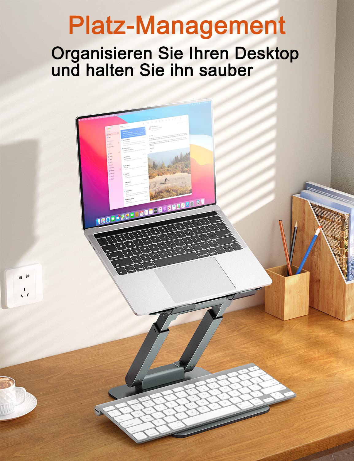 Laptop auf grauem Ständer, Tastatur davor. Der Ständer steht auf einem Holzschreibtisch. Text oben.