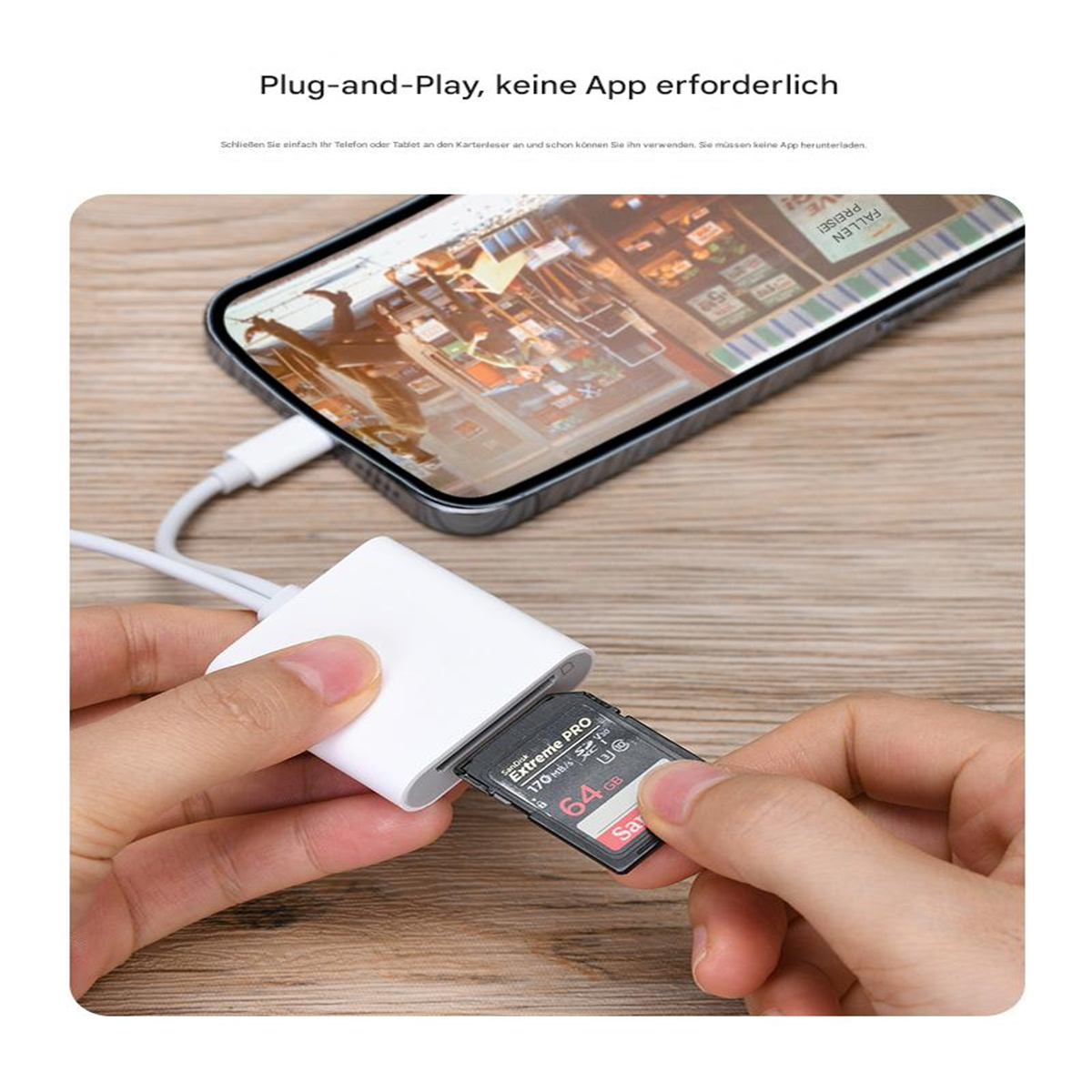 Hand steckt SD-Karte in weißes Kartenlesegerät, verbunden mit Telefon.