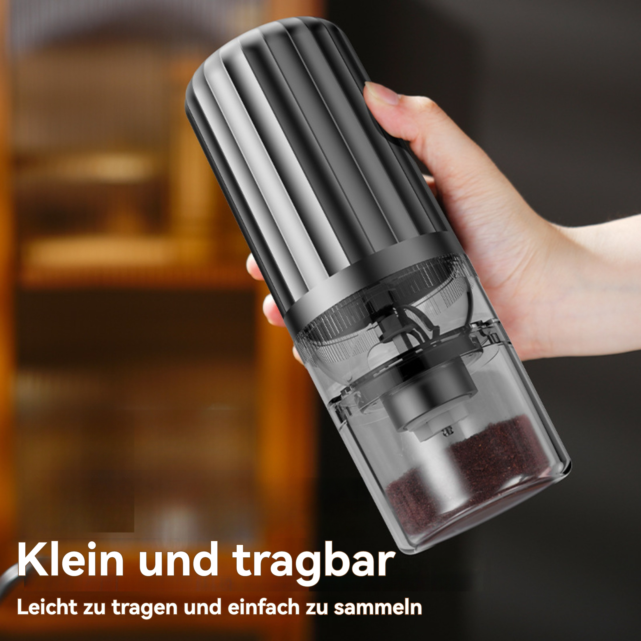 Eine Person hält eine schwarz-silberne elektrische Mühle. Die Mühle hat einen transparenten Behälter mit Inhalt.