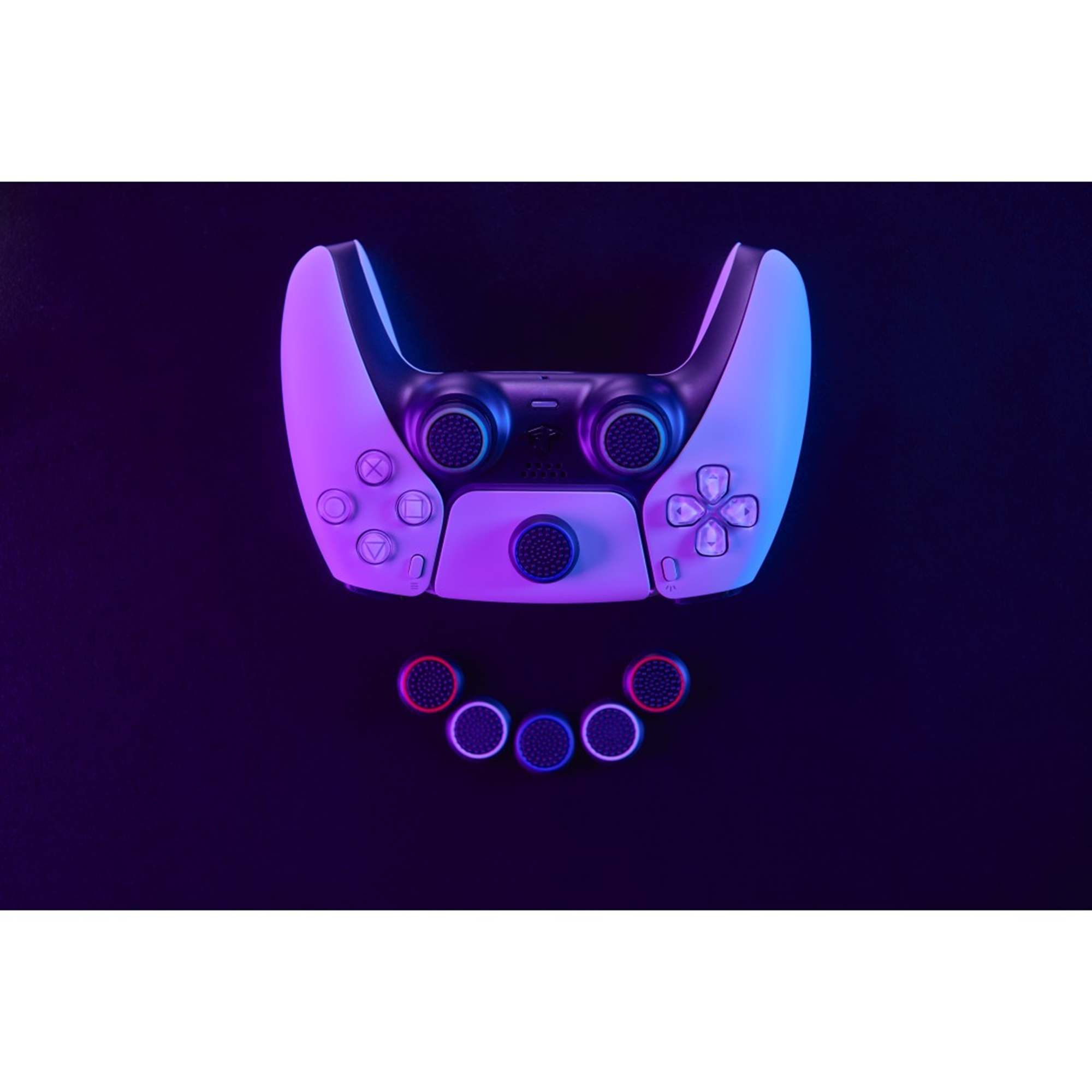 Schwarzer Gamecontroller mit farbigen Thumbsticks auf dunkler Oberfläche mit lila und blauer Beleuchtung.