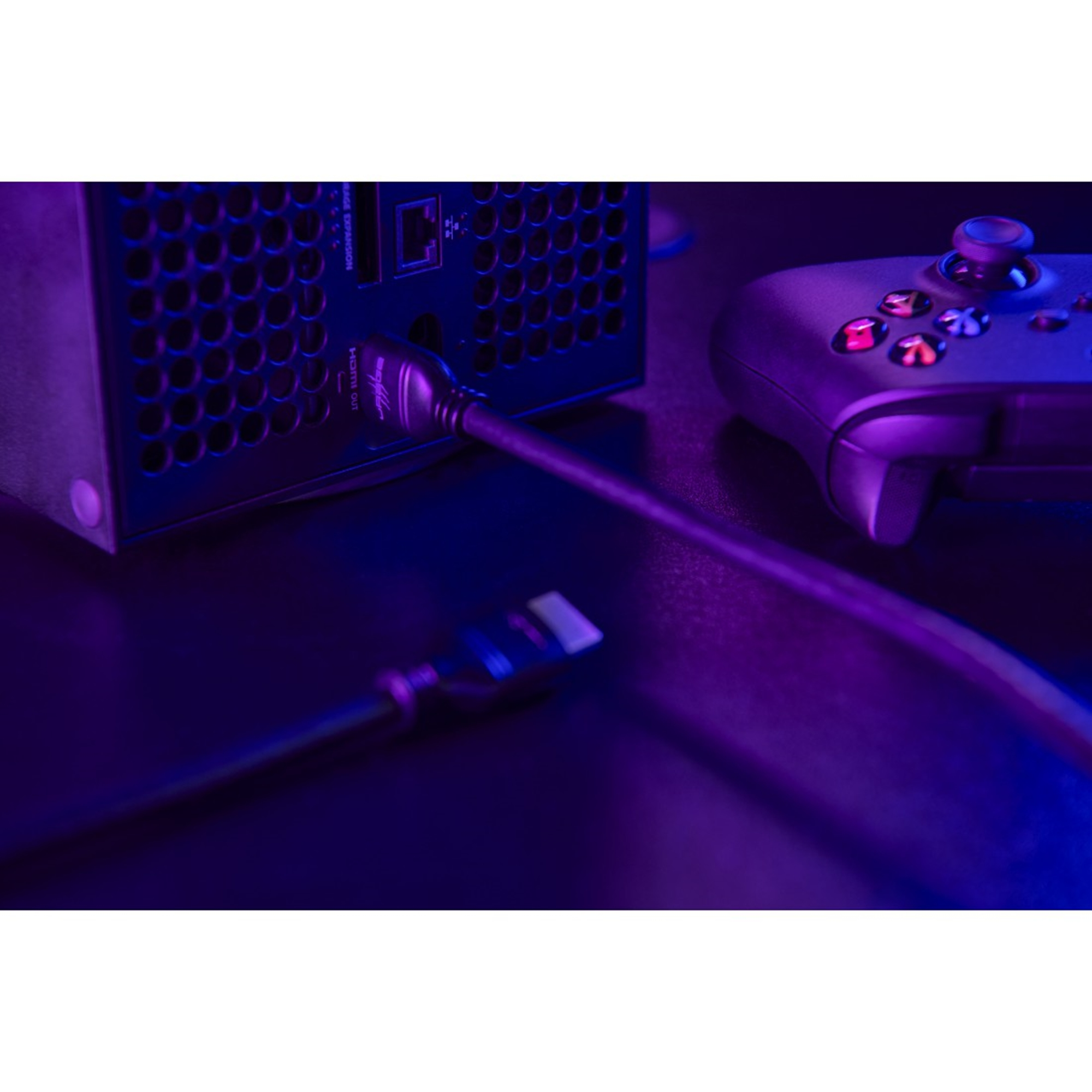 Nahaufnahme einer Spielkonsole und eines Controllers, die mit Kabeln verbunden sind, mit lila Farbton.
