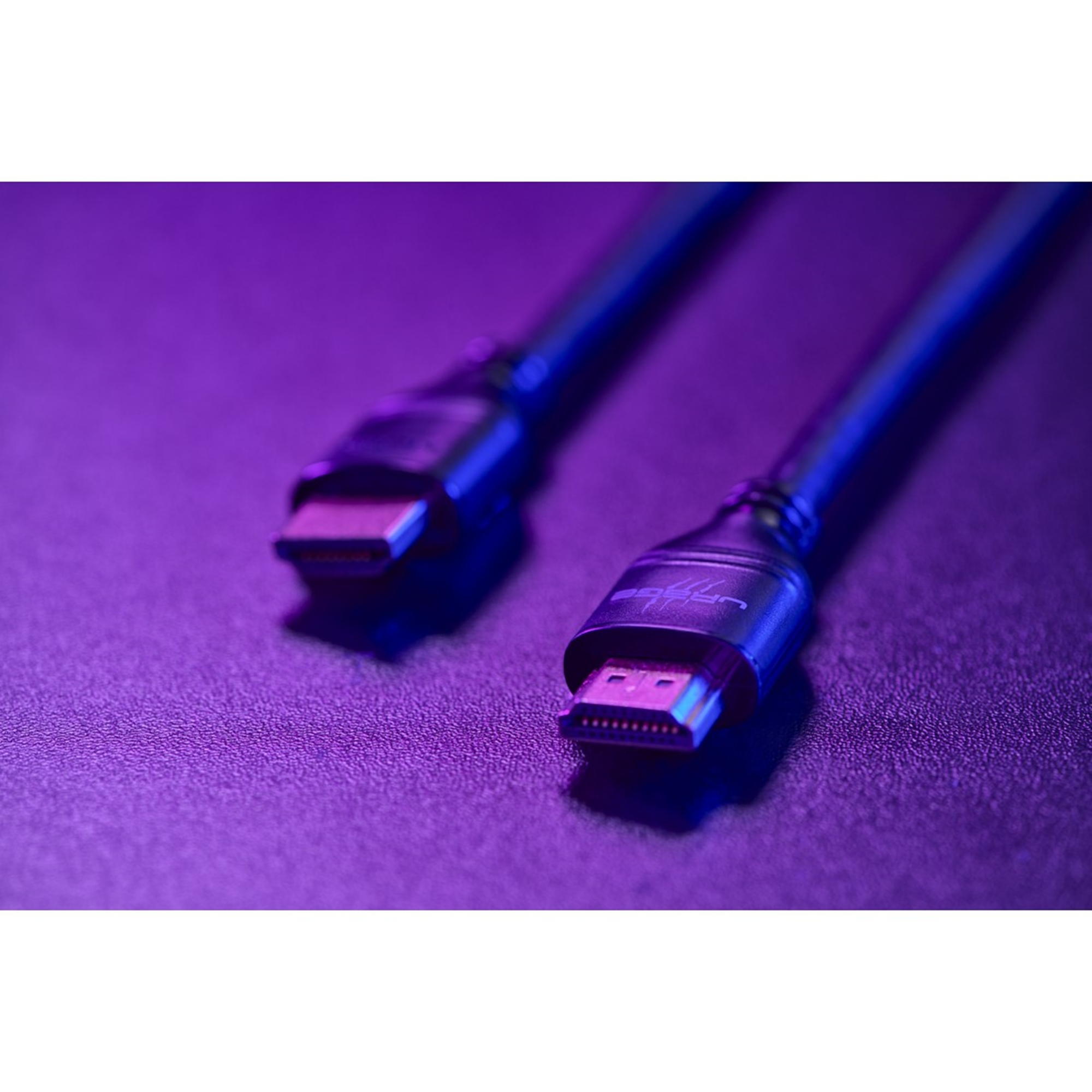 Zwei HDMI-Kabel mit goldenen Steckern auf einer lila beleuchteten Oberfläche.