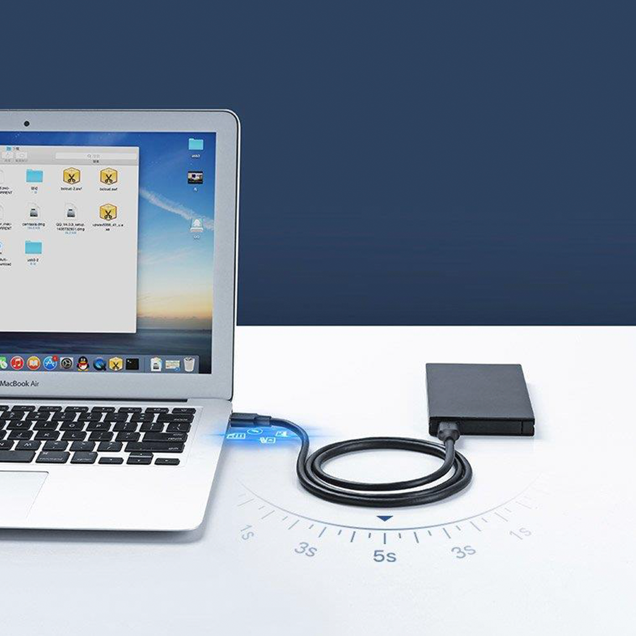 Laptop podłączony do zewnętrznego dysku twardego. Ekran laptopa wyświetla pliki i foldery.