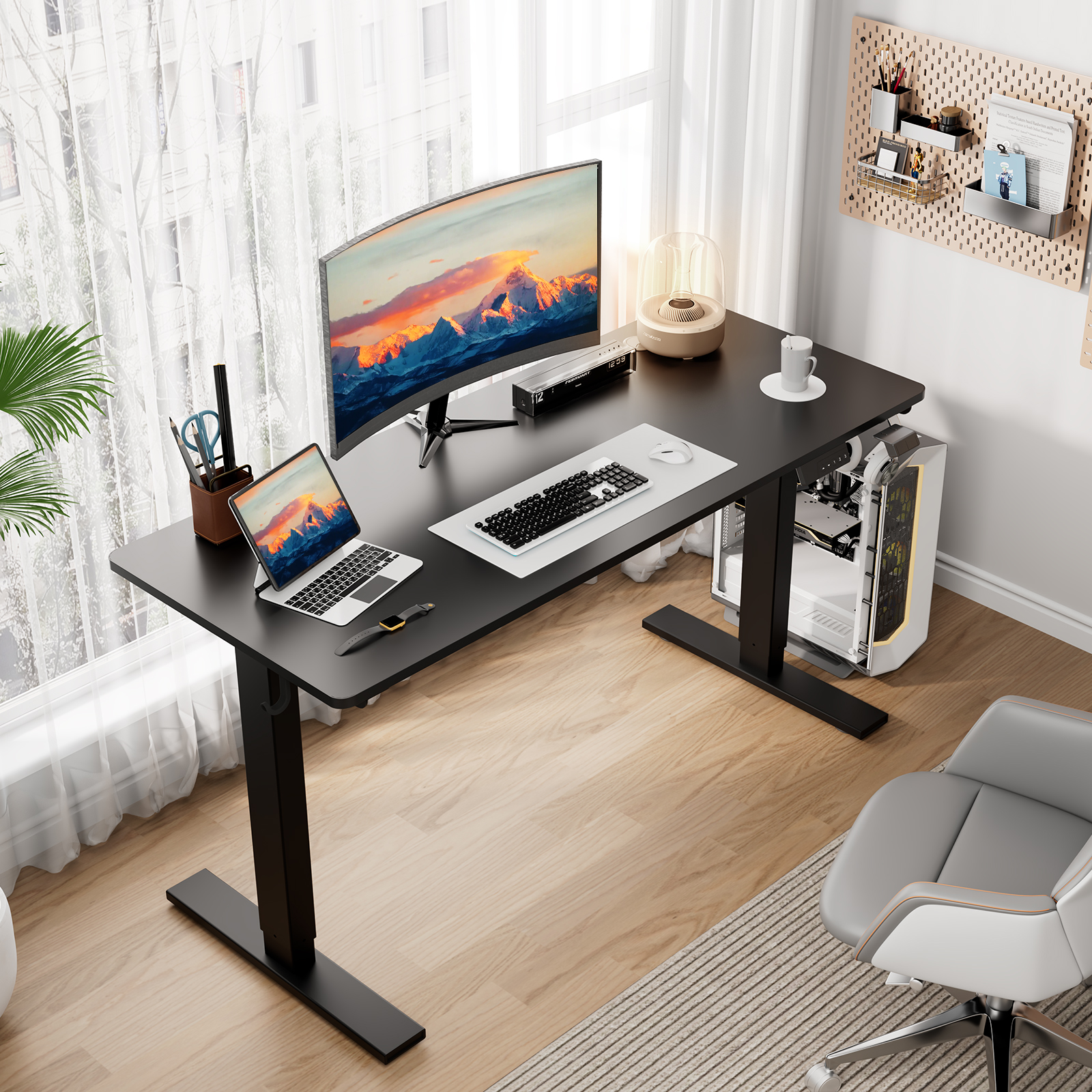 Zwart bureau met een laptop, monitor, toetsenbord en een computertoren. Een stoel staat in de hoek.