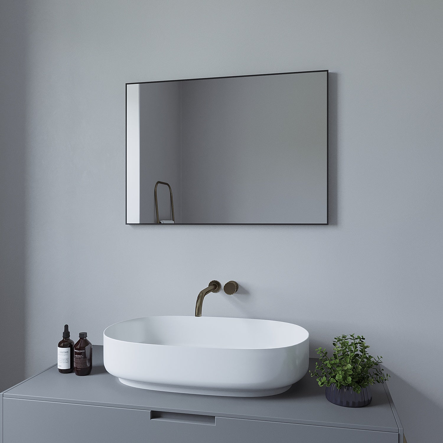 Badezimmer mit rechteckigem Spiegel in schwarzem Rahmen über weißem Waschbecken auf grauem Schrank.
