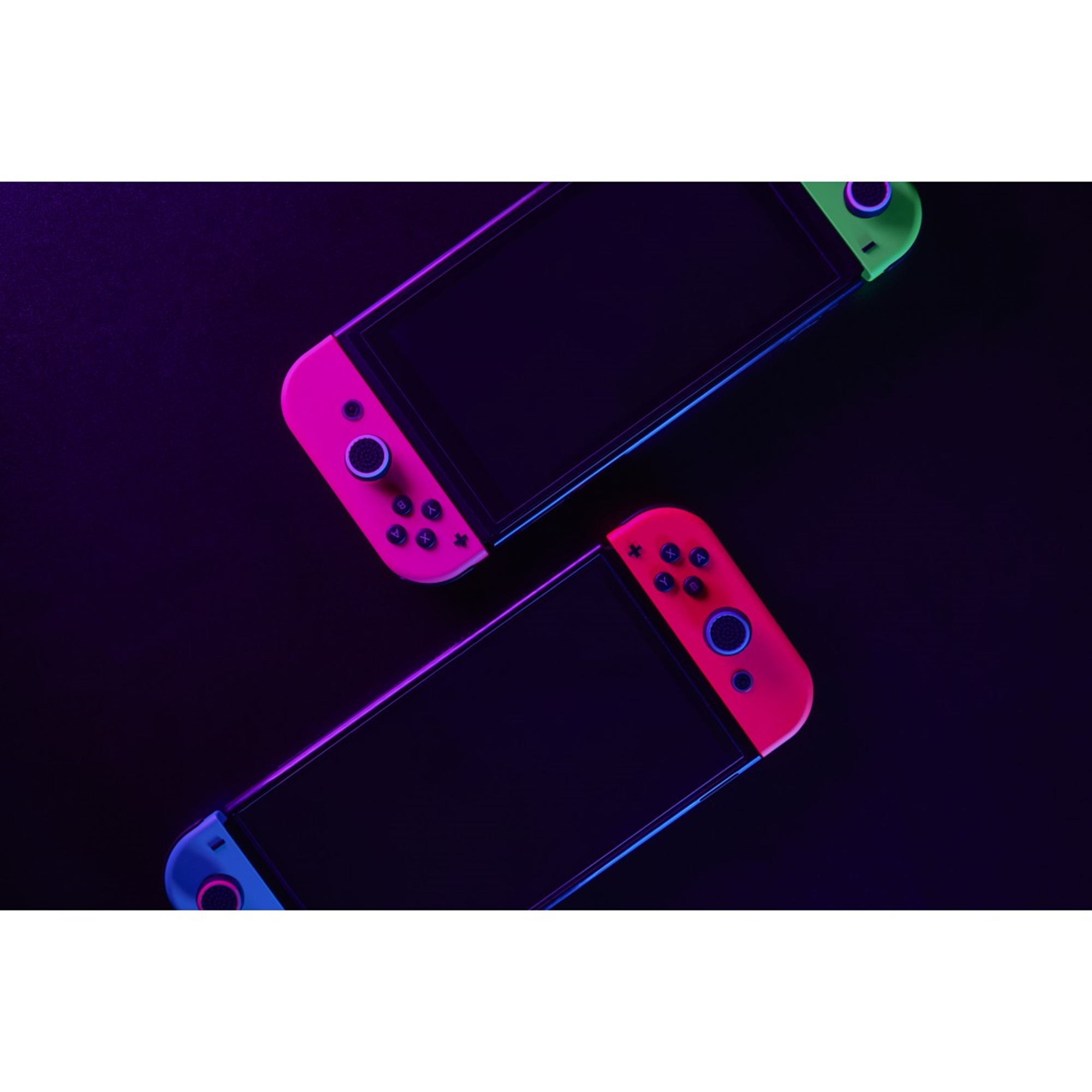 Zwei Nintendo Switch-Controller, rosa und grün, auf dunkler Oberfläche, mit schwarzem Hintergrund.